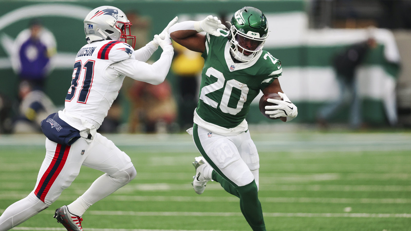 New York Jets running back Breece Hall (20) runs the ball against New England Patriots safety Craig Woodson (31) during the second half of the game at MetLife Stadium.