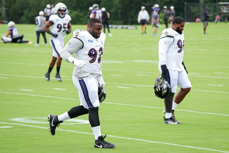 Baltimore Ravens defensive tackles Nnamdi Madubuike (92) and Broderick Washington Jr. (96) cross a practice field to join teammates during the team’s training camp at the Under Armour Performance Center in Owings Mills, Md. on Tuesday, August 19, 2025.