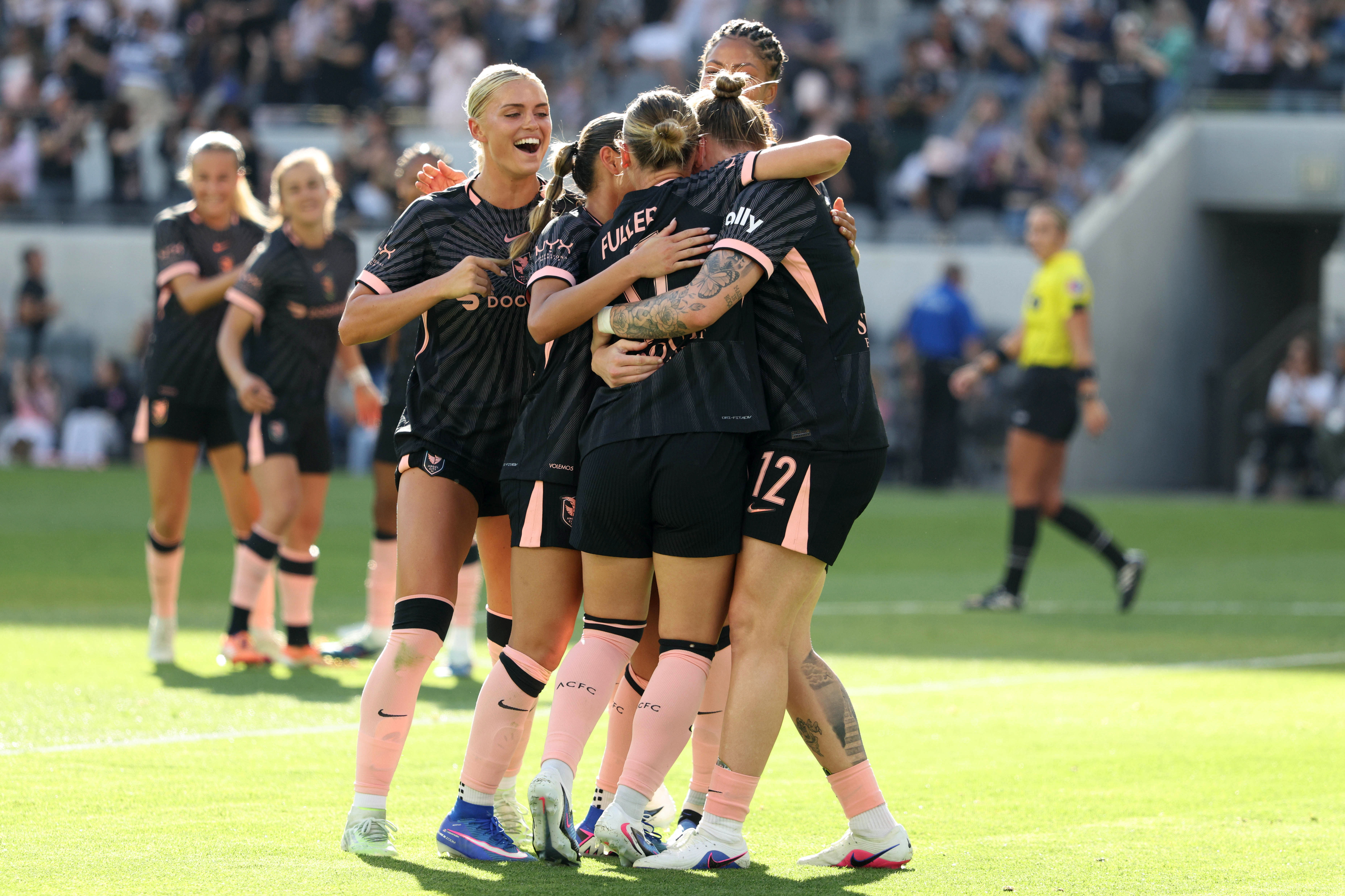 Angel City FC midfielder Kennedy Fuller, center, is mobbed by...