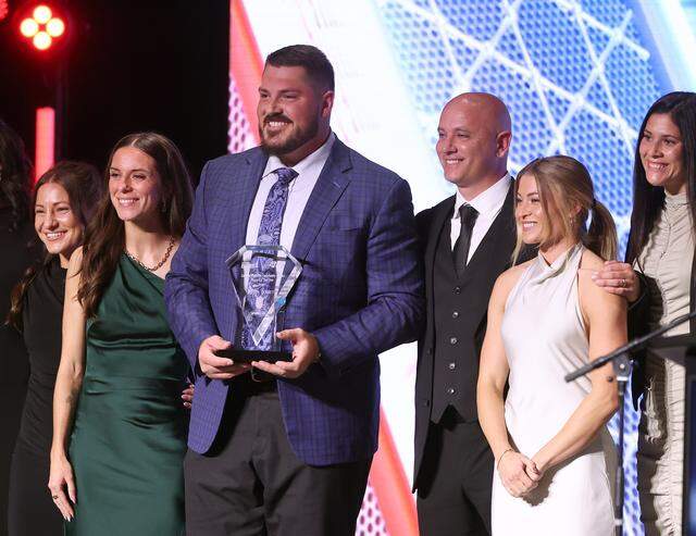 Offensive lineman Austin Corbett, center, wins the Carolina Panthers Community Impact Player of the Year Award during the Charlotte Touchdown Club’s 2025 Bronko Nagurski Awards program on Dec. 8, 2025.