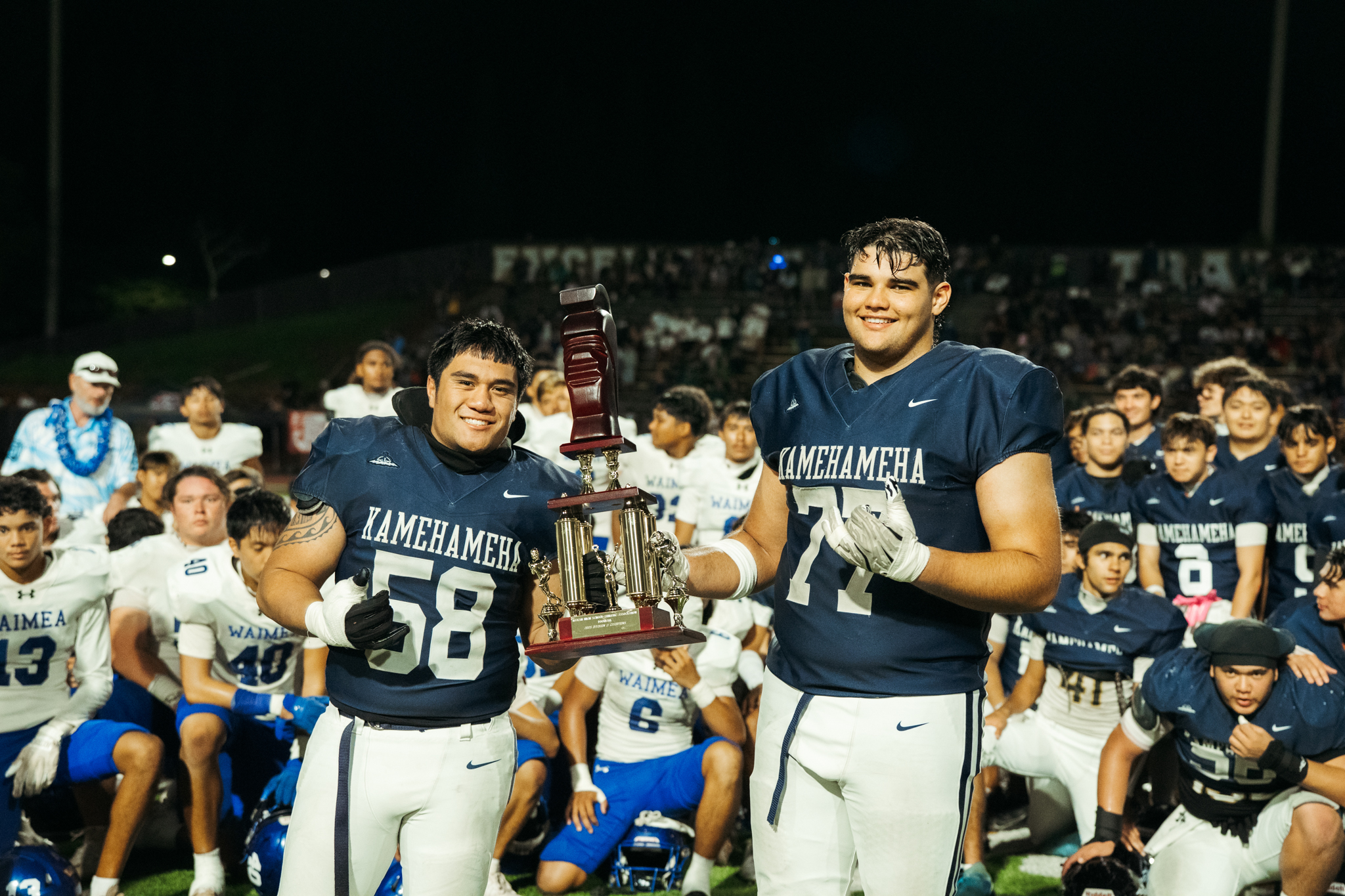 Kamehameha Schools Maui captains Kamahao Akima (58) and Pa'u Spencer show off the championship trophy after the Warriors' 48-24 win over Waimea on Nov. 28, 2025, at Mililani High School. SHANG ONG photo