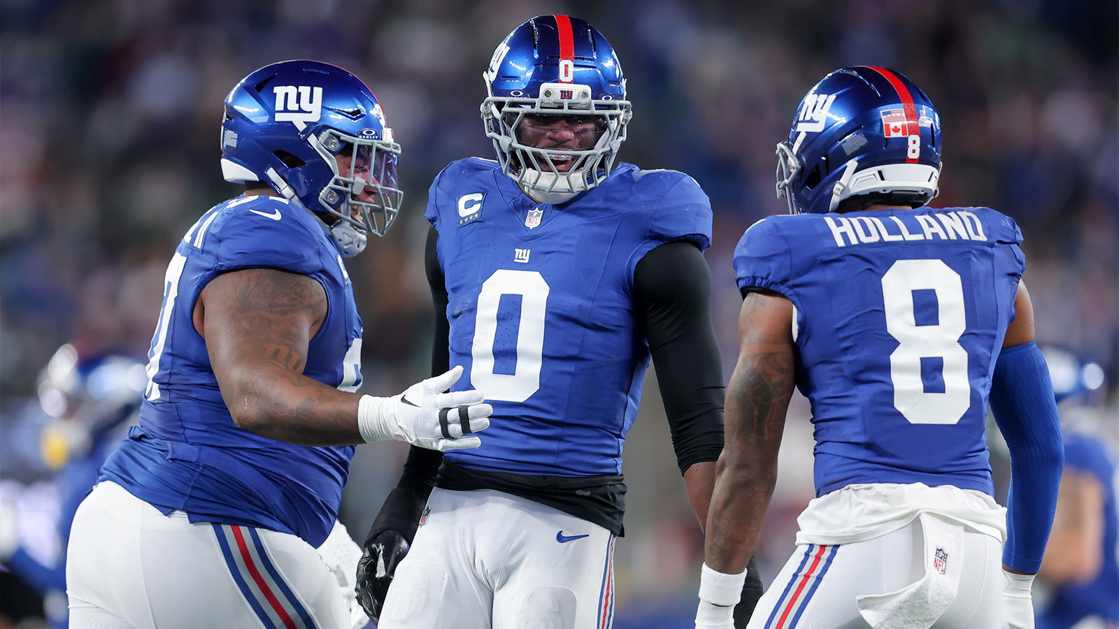 New York Giants linebacker Brian Burns (0) celebrates after a sack against the Philadelphia Eagles with defensive tackle Dexter Lawrence II (97) and safety Jevon Holland (8) during the first quarter of the game at MetLife Stadium.