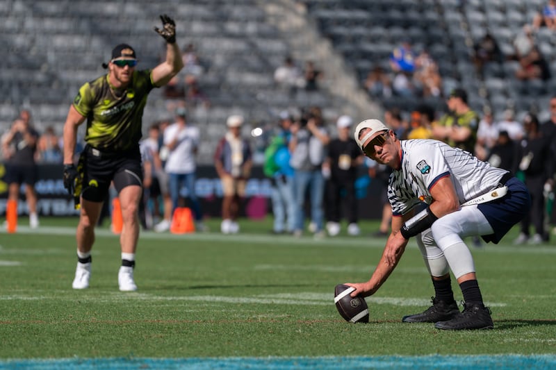 Logan Paul (left) on defense preparing for the snap from Tom Brady (right).