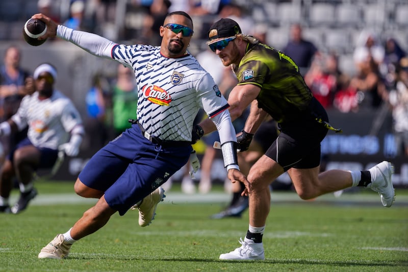 Jalen Hurts zips around encroaching defender Logan Paul with football in hand.