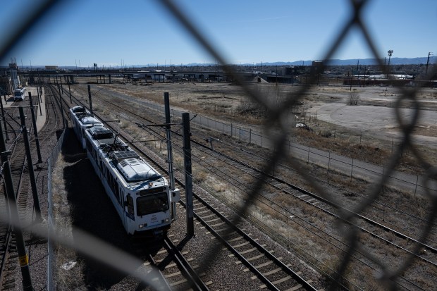 An RTD light rail train crosses under the Eighth Avenue viaduct with the south end of Burnham Yard visible to the right on Thursday, March 19, 2026, in Denver. (Photo by Timothy Hurst/The Denver Post)