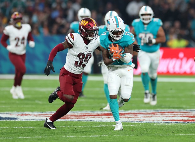 Jaylen Waddle of Miami Dolphins (#17) runs with the ball under pressure from Jeremy Reaves of Washington Commanders (#39) during the NFL 2025 game between Washington Commanders and Miami Dolphins at Estadio Santiago Bernabeu on Nov. 16, 2025 in Madrid, Spain. (Photo by Florencia Tan Jun/Getty Images)