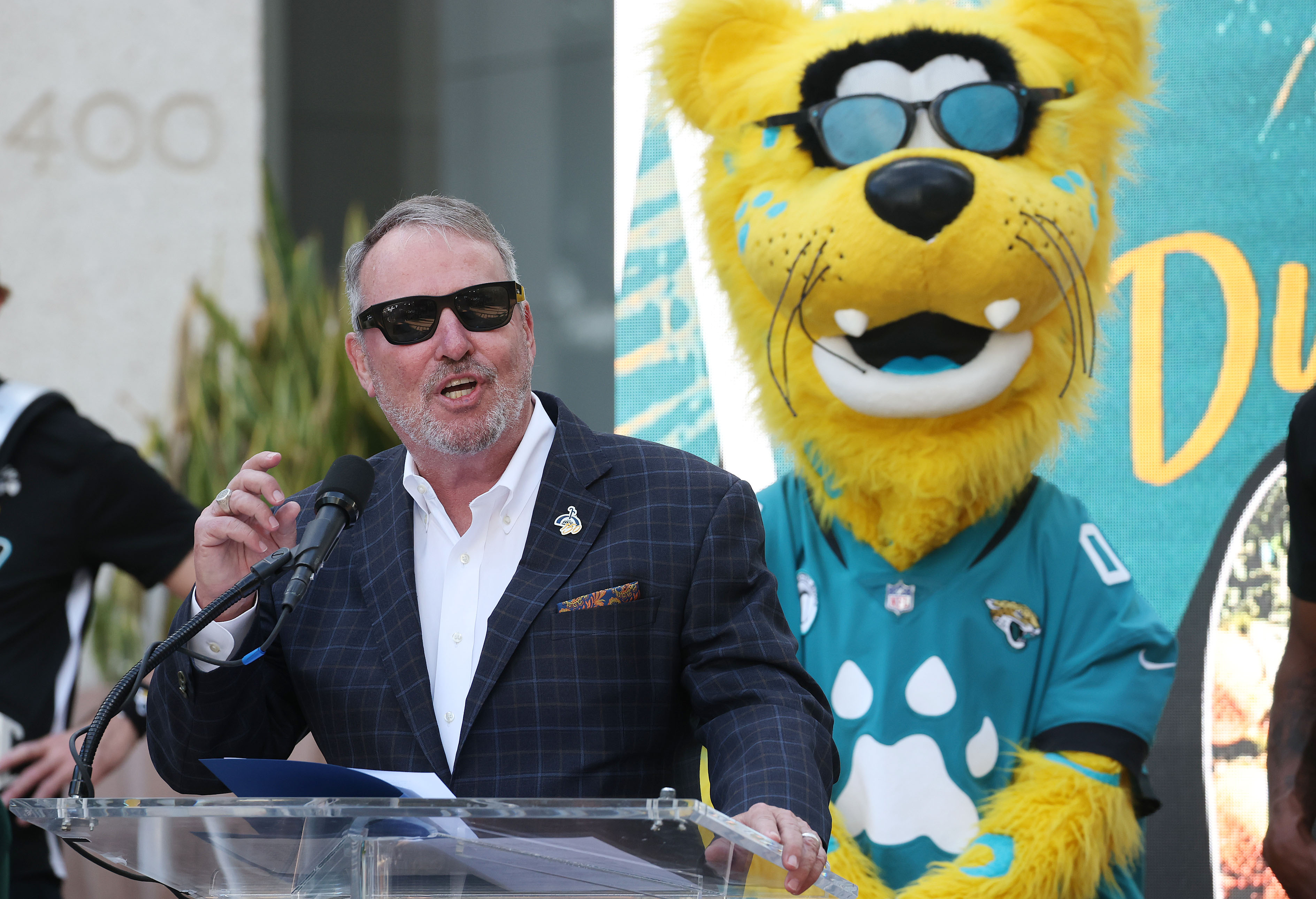 The Jaguars mascot stands behind Orlando Mayor Buddy Dyer during...