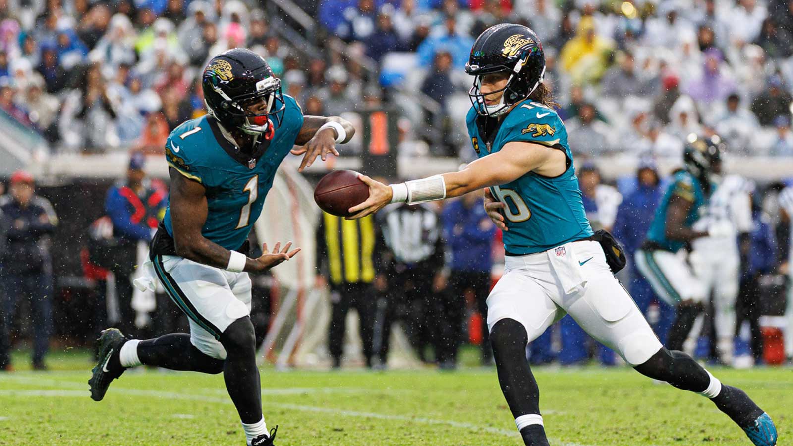 Jacksonville Jaguars quarterback Trevor Lawrence (16) hands the ball to Jacksonville Jaguars running back Travis Etienne Jr. (1) against the Indianapolis Colts during the second half at EverBank Stadium.
