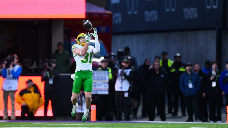 Oregon DB Dillon Thieneman intercepts a pass against Washington. vikings draft round 1 options 2026