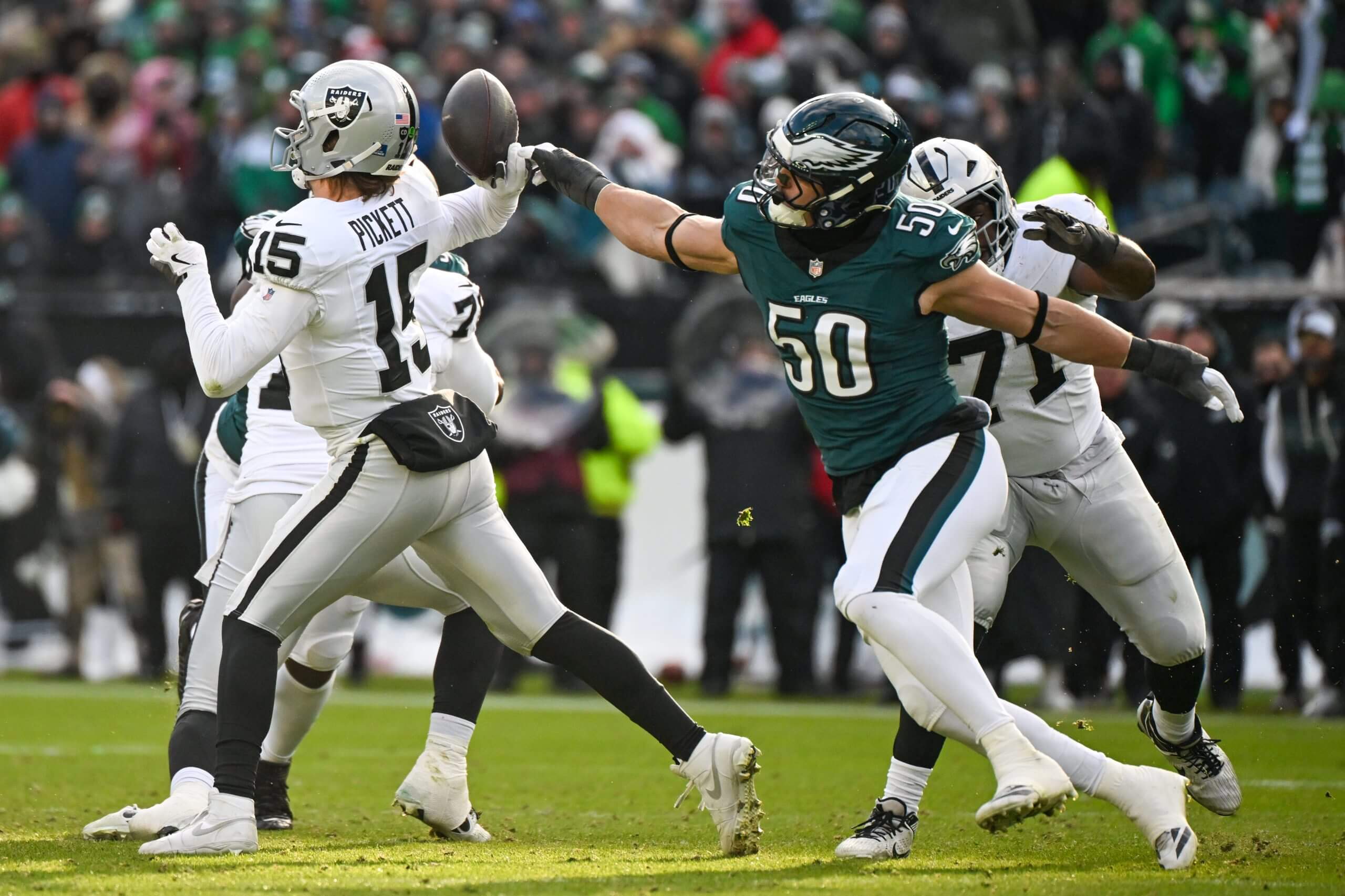 Las Vegas Raiders quarterback Kenny Pickett (15) throws the ball as Philadelphia Eagles linebacker Jaelan Phillips (50) hits his arm during the second quarter at Lincoln Financial Field.