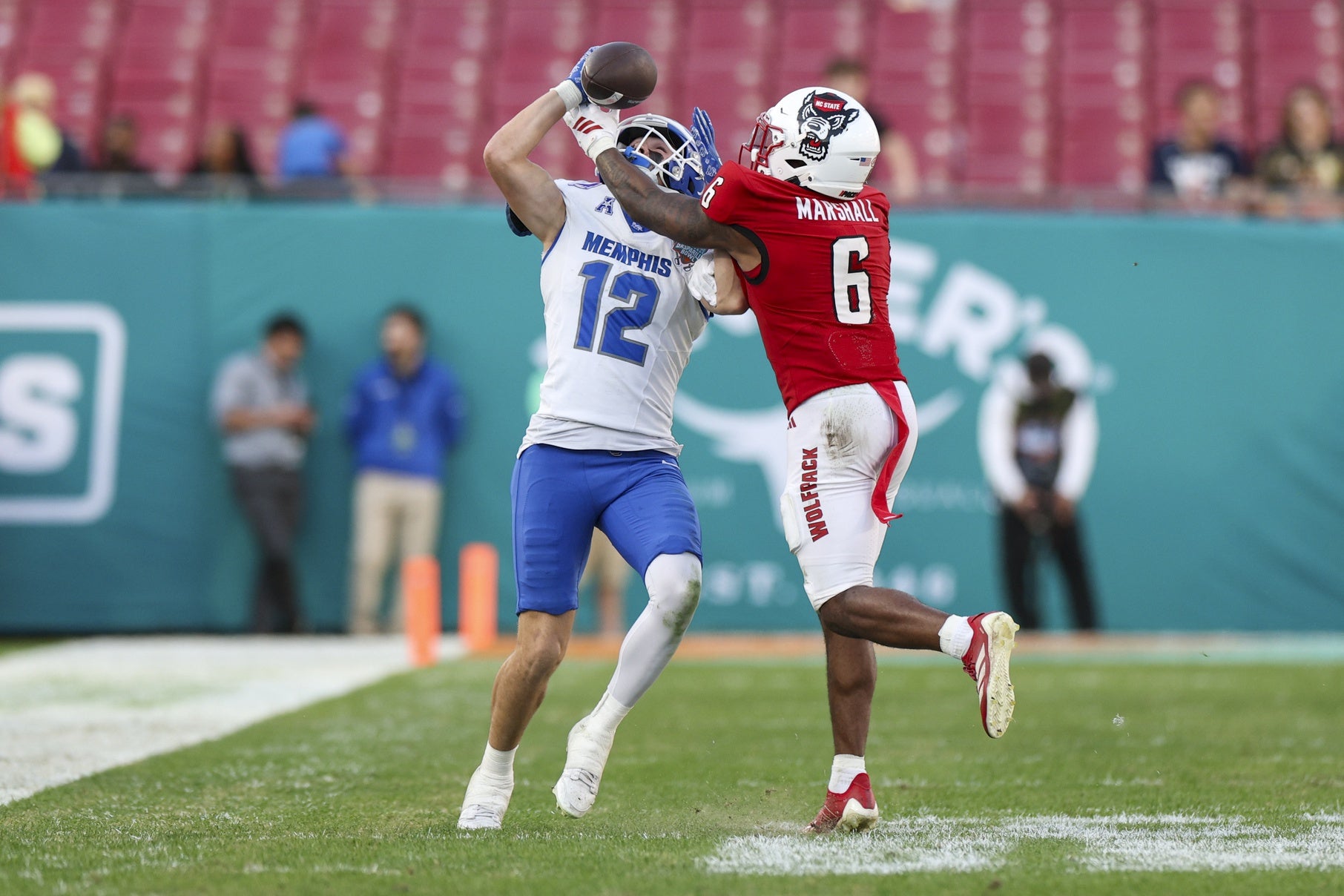 Dec 19, 2025; Tampa, FL, USA; NC State Wolfpack defensive back Devon Marshall (6) breaks up a pass to Memphis Tigers wide receiver Brady Kluse (12) in the third quarter during the Gasparilla Bowl at Raymond James Stadium. Mandatory Credit: Nathan Ray Seebeck-Imagn Images