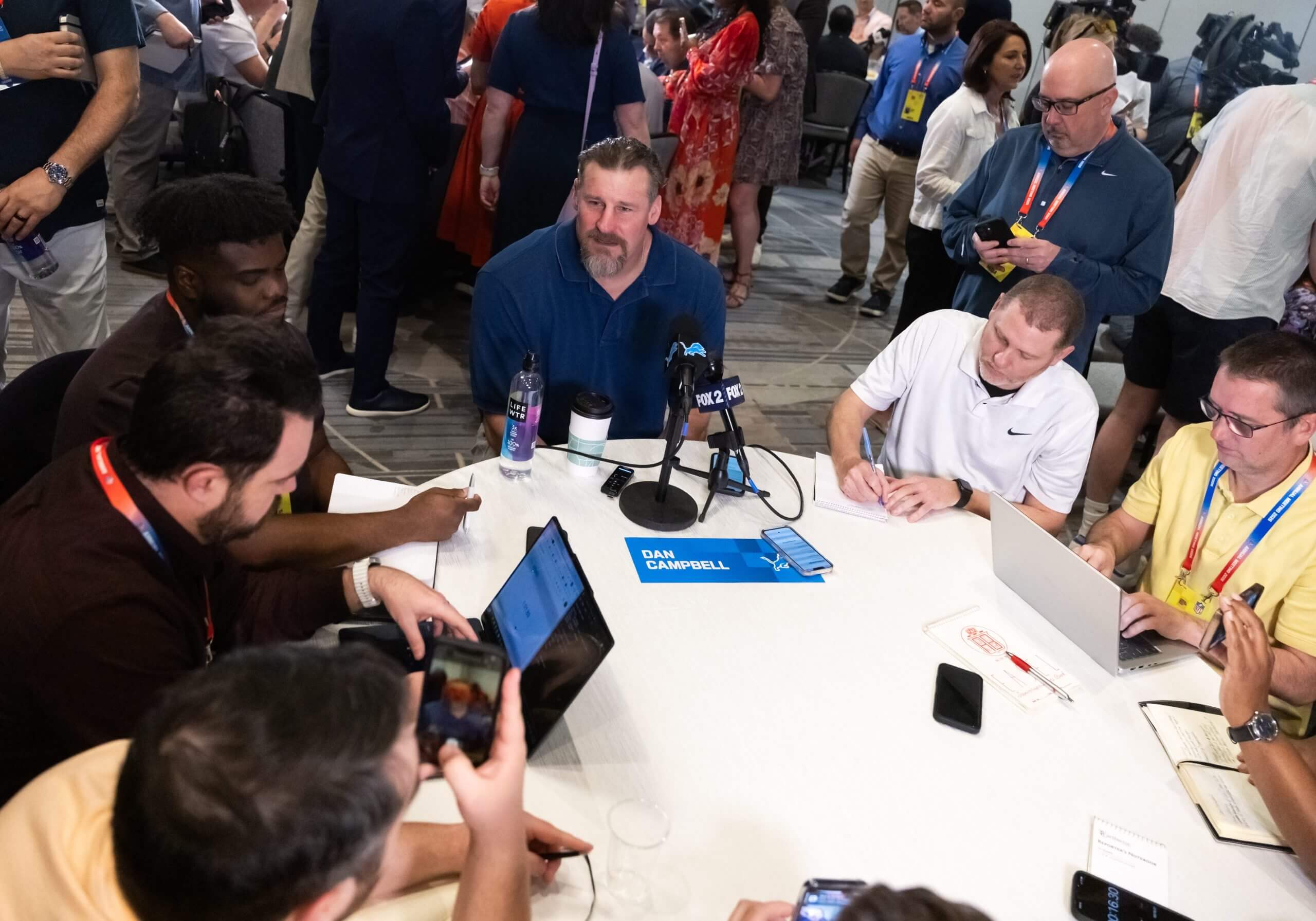 Detroit Lions head coach Dan Campbell (center) speaks to reporters and the media during the 2026 NFL Annual League Meeting at the Arizona Biltmore.