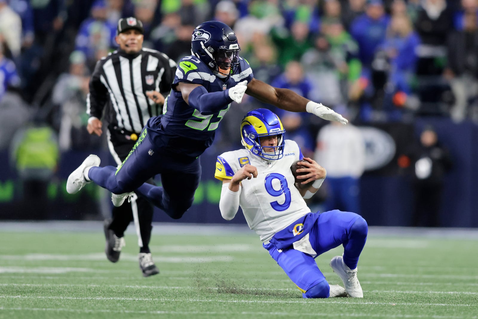 FILE - Los Angeles Rams quarterback Matthew Stafford (9) slides to the ground with Seattle Seahawks linebacker Boye Mafe (53) leaping behind in the NFC Championship NFL football game, Sunday, Jan. 25, 2026, in Seattle. (AP Photo/John Froschauer,File)