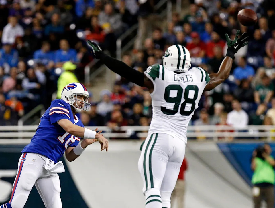 Buffalo Bills quarterback Kyle Orton throws a pass as New York Jets outside linebacker Quinton Coples reaches to block it.
