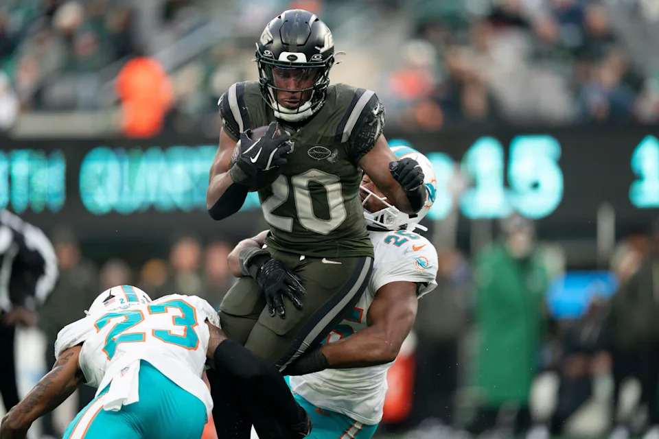 New York Jets running back Breece Hall (20) runs the ball before being tackled by Miami Dolphins linebacker Tyrel Dodson (25) during a week 14 football game between the New York Jets and Miami Dolphins at MetLife Stadium on Sunday, Dec. 7, 2025.