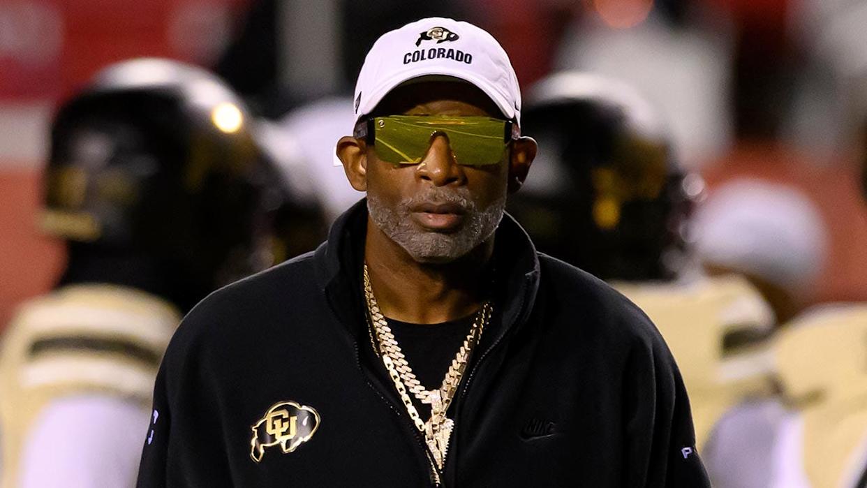 Deion Sanders watches his players warm up