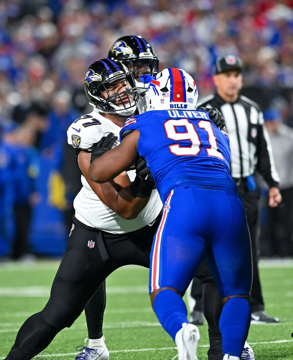 Sep 7, 2025; Orchard Park, New York, USA; Baltimore Ravens guard Daniel Faalele (77) blocks Buffalo Bills defensive tackle Ed Oliver (91) in the first quarter at Highmark Stadium. Mandatory Credit: Mark Konezny-Imagn Images