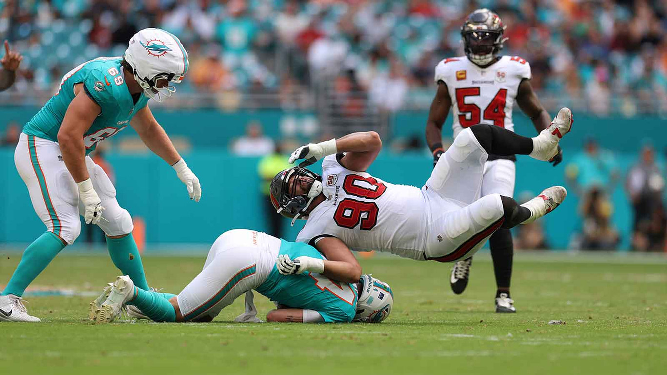 Miami Dolphins quarterback Quinn Ewers (14) is sacked by Tampa Bay Buccaneers defensive end Logan Hall (90) during the second quarter at Hard Rock Stadium.