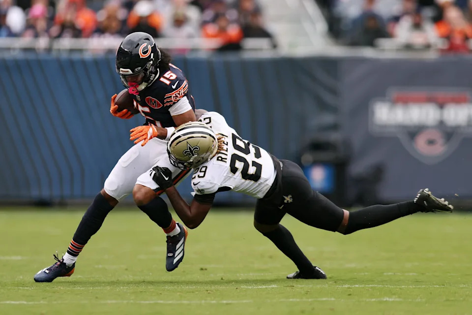 CHICAGO, ILLINOIS - OCTOBER 19: Quincy Riley #29 of the New Orleans Saints tackles Rome Odunze #15 of the Chicago Bears during the first half of the game at Soldier Field on October 19, 2025 in Chicago, Illinois. (Photo by Geoff Stellfox/Getty Images)