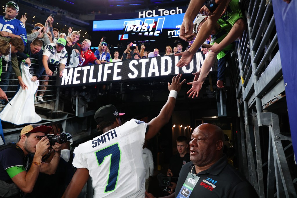 Seattle Seahawks quarterback Geno Smith (7) high-fives fans after the game at MetLife Stadium.