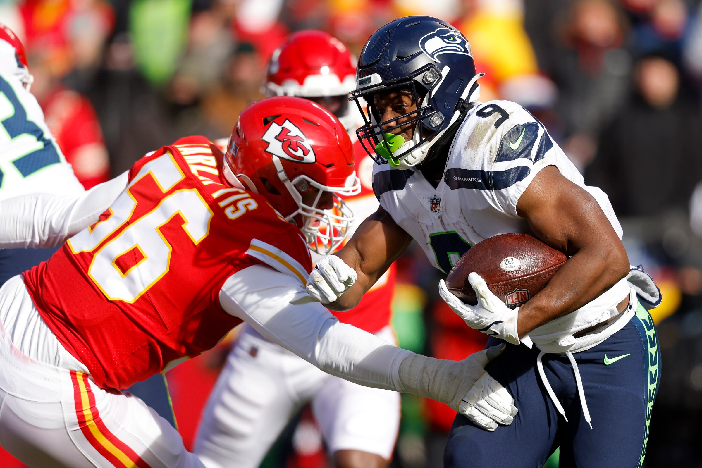 KANSAS CITY, MISSOURI - DECEMBER 24: George Karlaftis #56 of the Kansas City Chiefs tackles Kenneth Walker III #9 of the Seattle Seahawks during the second quarter at Arrowhead Stadium on December 24, 2022 in Kansas City, Missouri. (Photo by David Eulitt/Getty Images)