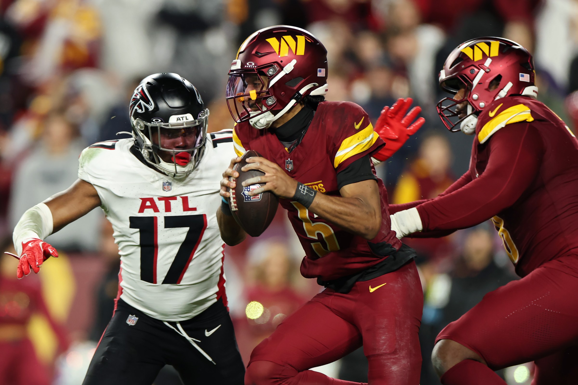 LANDOVER, MARYLAND - DECEMBER 29: Jayden Daniels #5 of the Washington Commanders drops back to pass while being pressured by Arnold Ebiketie #17 of the Atlanta Falcons in the third quarter at Northwest Stadium on December 29, 2024 in Landover, Maryland. (Photo by Scott Taetsch/Getty Images)