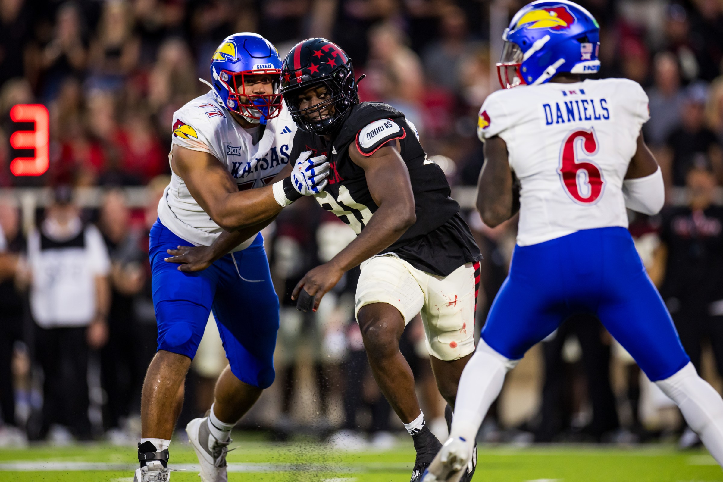 LUBBOCK, TEXAS - OCTOBER 11: David Bailey #31 of the Texas Tech Red Raiders rushes past Enrique Cruz Jr. #77 of the Kansas Jayhawks during the first half of the game at Jones AT&T Stadium on October 11, 2025 in Lubbock, Texas. (Photo by John E. Moore III/Getty Images)