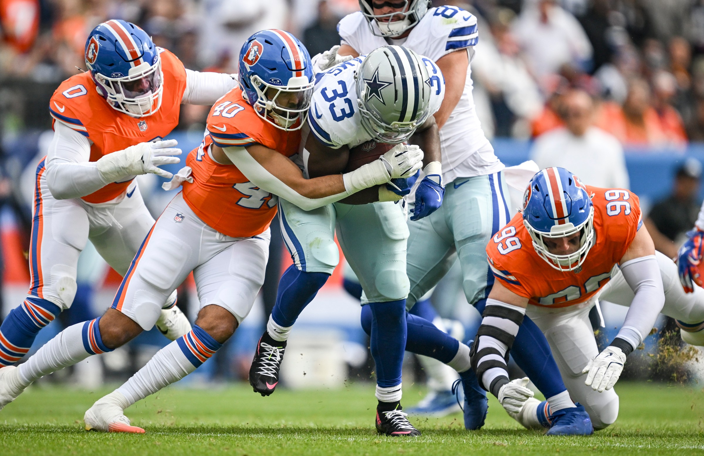DENVER , CO - OCTOBER 26: Justin Strnad (40) of the Denver Broncos tackles Javonte Williams (33) of the Dallas Cowboys during the first quarter at Empower Field at Mile High in Denver on Sunday, October 26, 2025. (Photo by AAron Ontiveroz/The Denver Post)