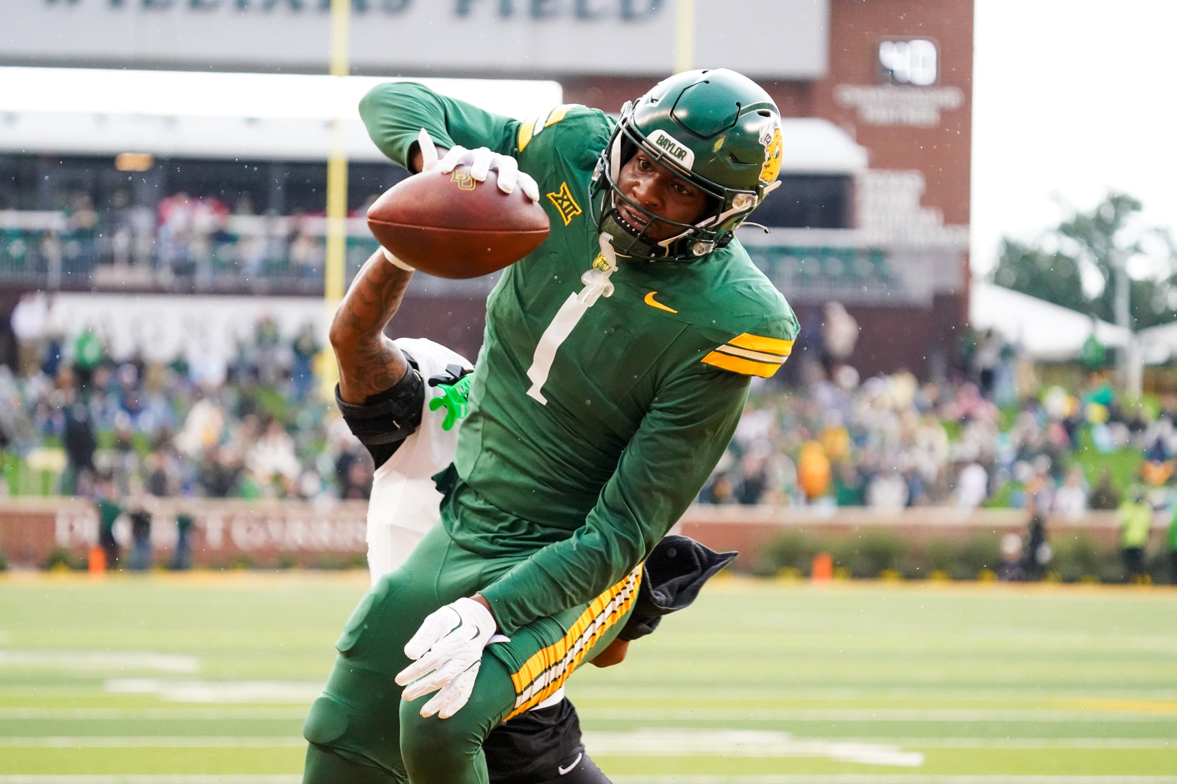 Nov 1, 2025; Waco, Texas, USA; Baylor Bears tight end Michael Trigg (1) catches a touchdown pass as UCF Knights defensive back Braeden Marshall (4) defends during the first half at McLane Stadium. Mandatory Credit: Raymond Carlin III-Imagn Images