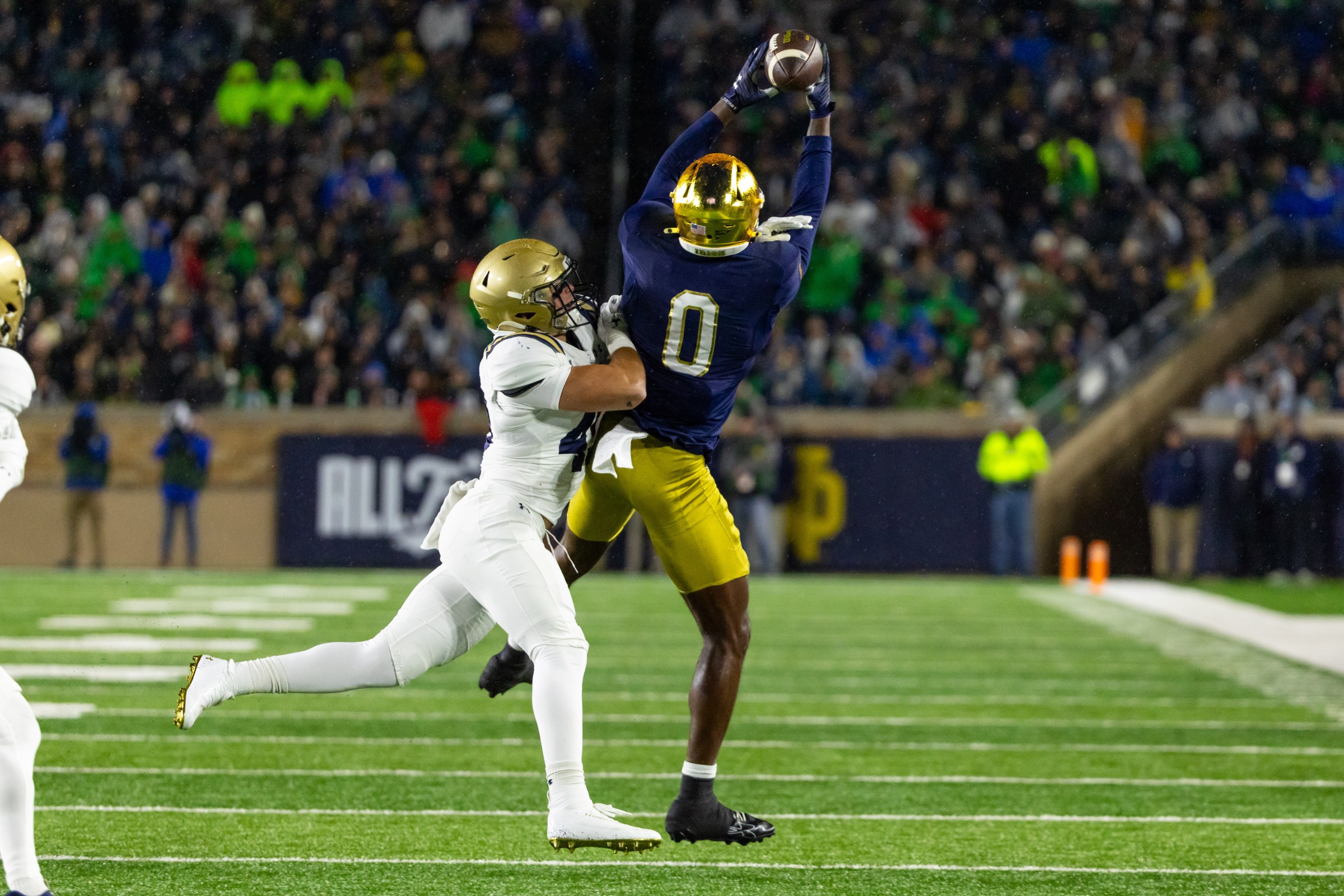 Nov 8, 2025; South Bend, Indiana, USA; Notre Dame Fighting Irish wide receiver Malachi Fields (0) makes a catch as Navy Midshipmen linebacker Adam Klenk (49) defends during the first half at Notre Dame Stadium. Mandatory Credit: Michael Caterina-Imagn Images