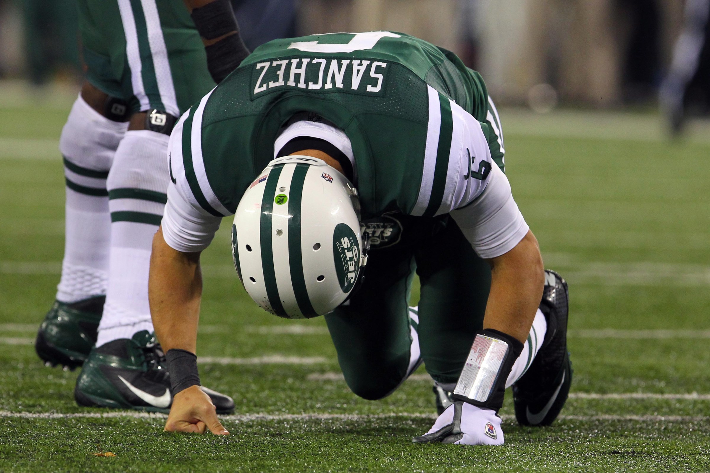 Nov 22, 2012; East Rutherford, NJ, USA; New York Jets quarterback Mark Sanchez (6) reacts and gets up from the turf after being hit during the second half on Thanksgiving against the New England Patriots at Metlife Stadium. Patriots defeated the Jets 49-19. Mandatory Credit: Ed Mulholland-Imagn Images