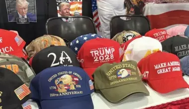 A vendor booth showcases pro-Trump hats and apparel, including “Make America Great Again” and “Trump 2028” merchandise, at CPAC.