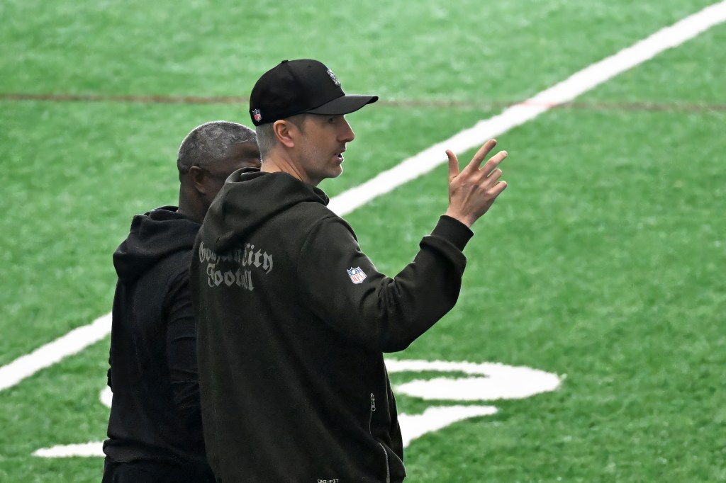 Jets general manager Darren Mougey talking to coach Aaron Glenn on the practice field.