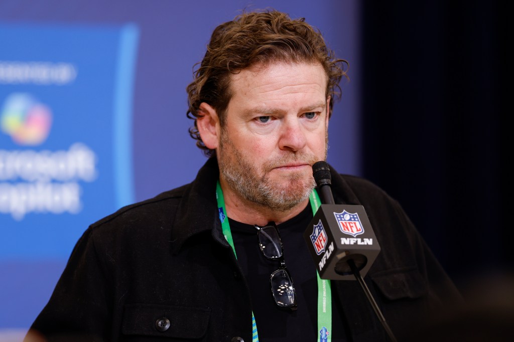 John Schneider, General Manager of the Seattle Seahawks, speaks into a microphone at the 2026 NFL Scouting Combine.