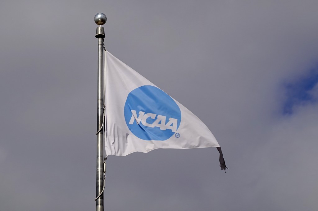 NCAA logo flag flying from a flagpole against a cloudy sky.