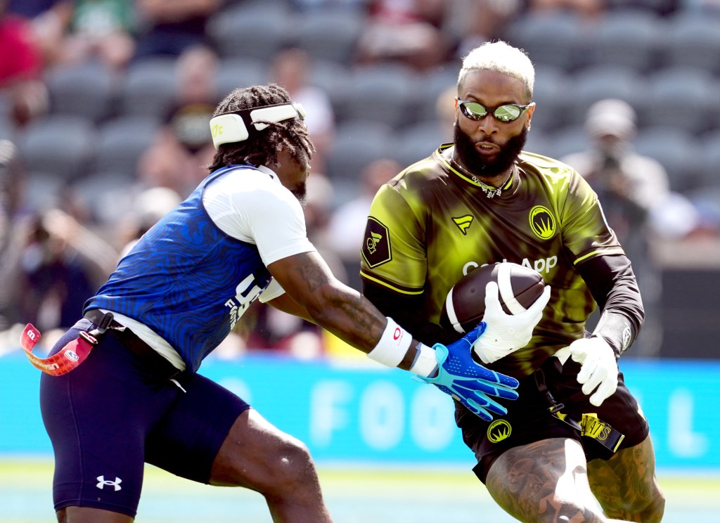 Odell Beckham Jr. with a football juking Aamir Brown during the Fanatics Flag Football Classic.
