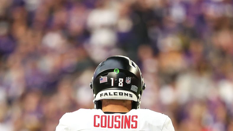 Kirk Cousins stands on the sideline watching play during a Falcons vs Vikings game. Vikings rumors.