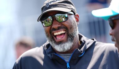 Detroit Lions executive vice president and general manager Brad Holmes laughs with Miami Dolphins coaches during a joint practice at the Lions headquarters and training facility in Allen Park, Thursday, Aug. 14, 2025.