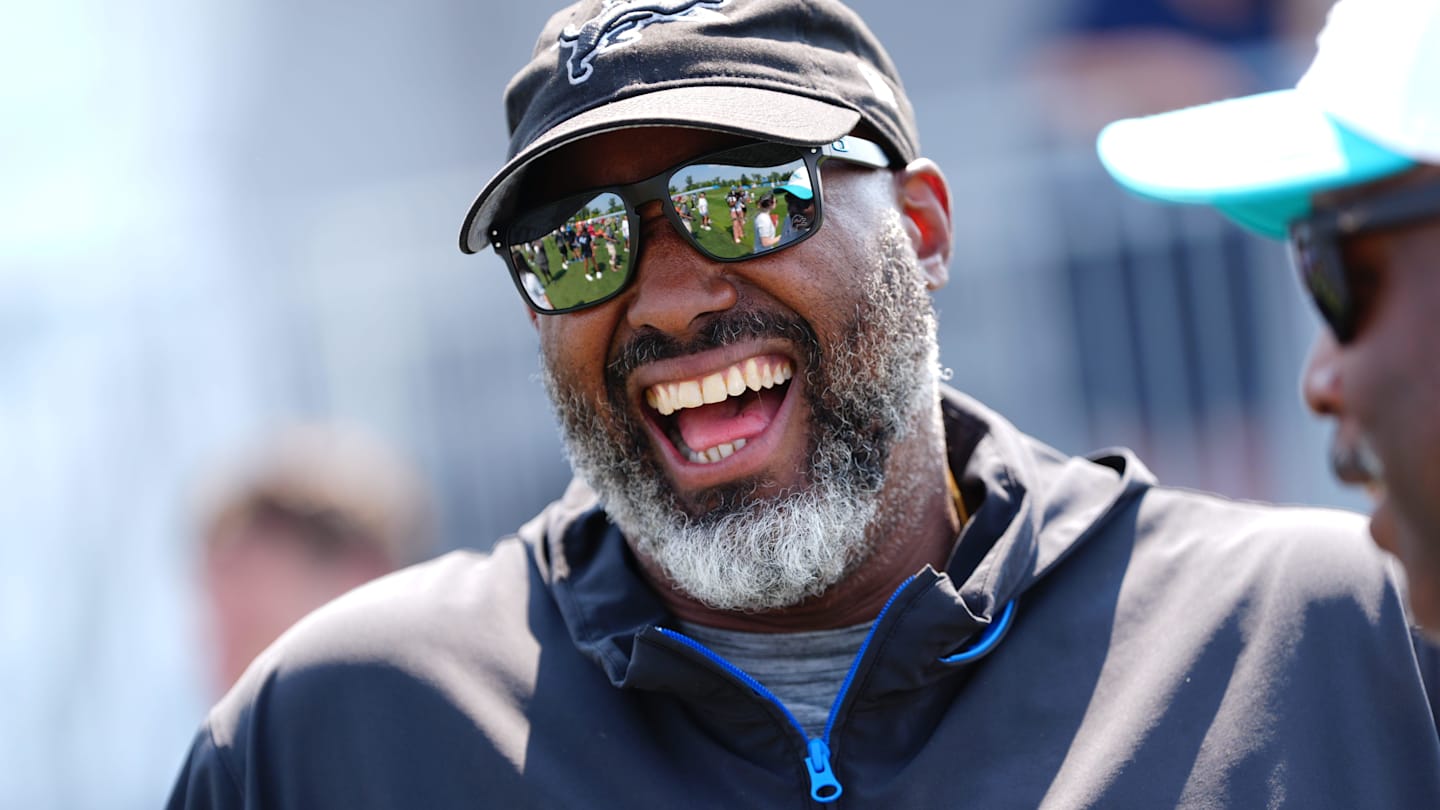Detroit Lions executive vice president and general manager Brad Holmes laughs with Miami Dolphins coaches during a joint practice at the Lions headquarters and training facility in Allen Park, Thursday, Aug. 14, 2025.
