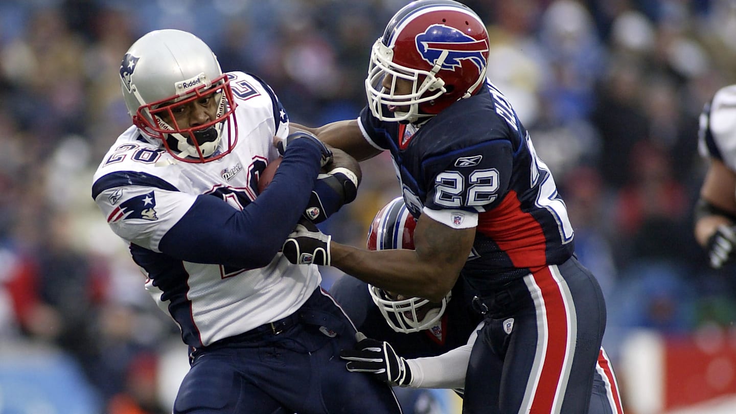 Dec 11, 2005; Orchard Park, NY, USA; FILE PHOTO; New England Patriots running back Corey Dillon (28) carries the ball as he is chased by Buffalo Bills defensive back Nate Clements (22) at Ralph Wilson Stadium. The Patriots defeated the Bills 35-7. Mandatory Credit: MPS-Imagn Images