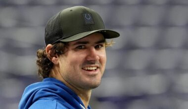 An injured Indianapolis Colts quarterback Daniel Jones talks with team staff