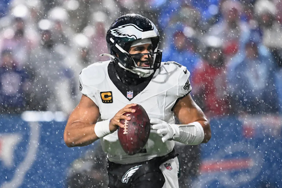 Jalen Hurts looks to throw a pass in heavy rain at Highmark Stadium. Mandatory Credit: Mark Konezny-Imagn Images
