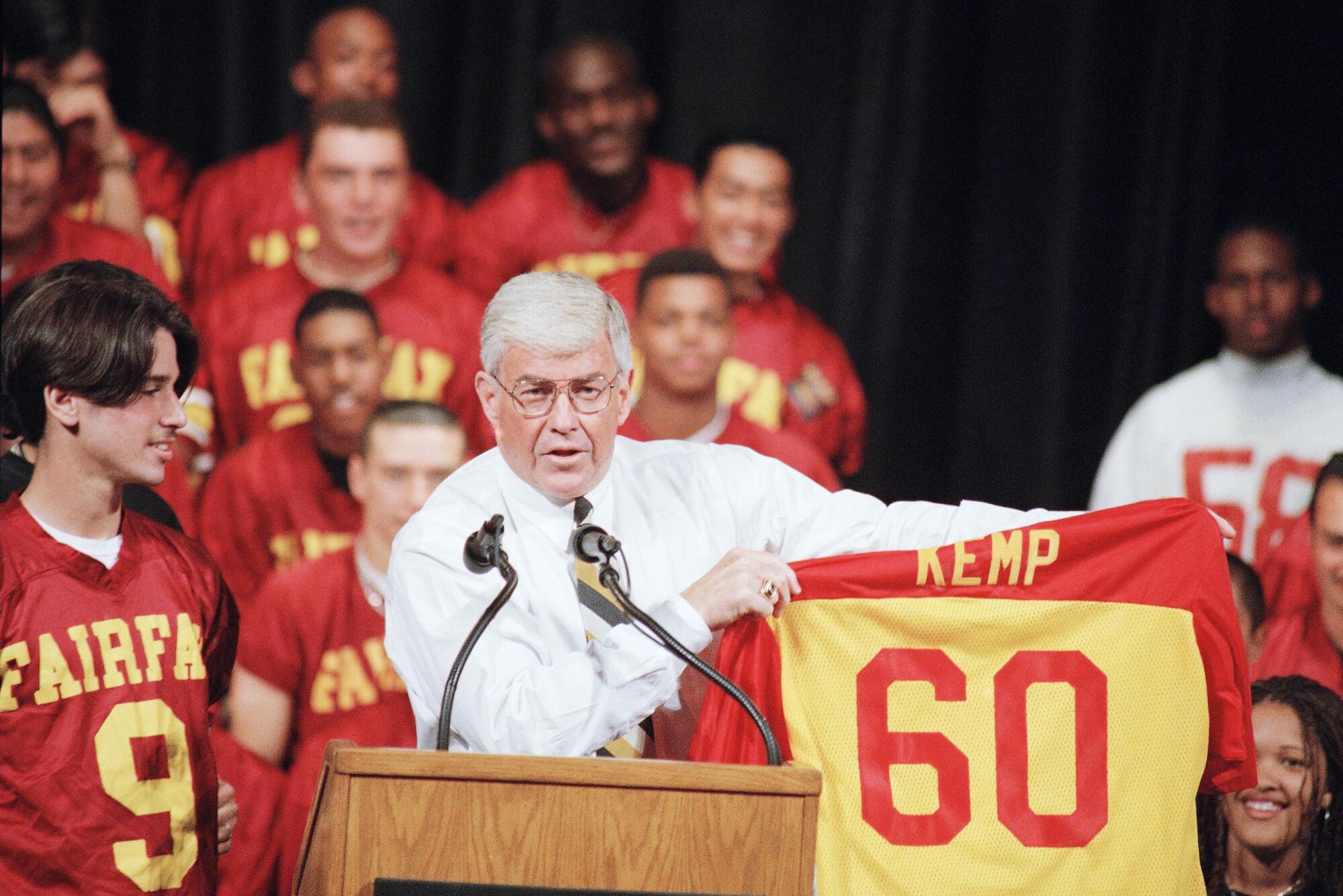 Republican vice presidential candidate Jack Kemp accepts a jersey from football players at Fairfax High in 1996.