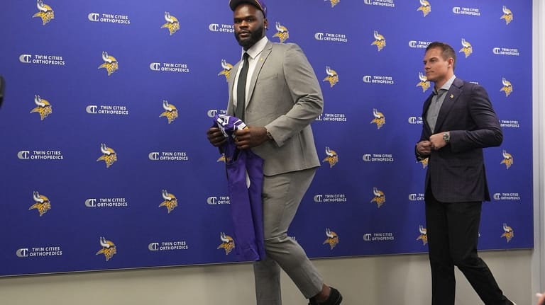 Minnesota Vikings first round draft pick Caleb Banks, left, and...