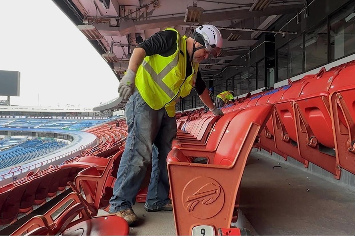 Construction workers take apart parts of Highmark Stadium.  (Sam Siegel / NBC News)