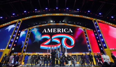 College players stand on the stage as flags are presented during the first round of the NFL foo ...