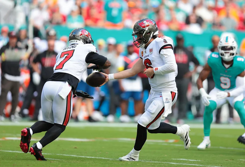 Dec 28, 2025; Miami Gardens, Florida, USA; Tampa Bay Buccaneers quarterback Baker Mayfield (6) hands the ball off to running back Bucky Irving (7) during the first quarter at Hard Rock Stadium. Mandatory Credit: Sam Navarro-Imagn Images
