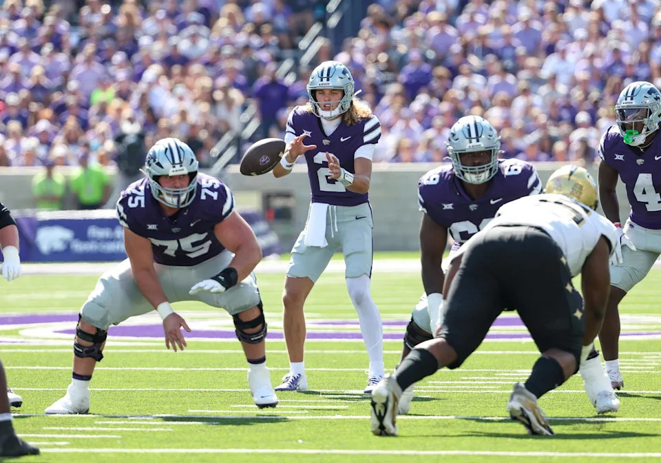 Sep 27, 2025; Manhattan, Kansas, USA; Kansas State Wildcats quarterback Avery Johnson (2) takes the snap from center Sam Hecht (75) during the second quarter against the UCF Knights at Bill Snyder Family Football Stadium. Mandatory Credit: Scott Sewell-Imagn Images