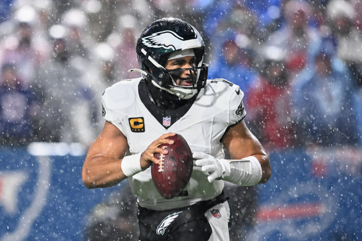 Jalen Hurts looks to throw a pass in heavy rain at Highmark Stadium. Mandatory Credit: Mark Konezny-Imagn Images