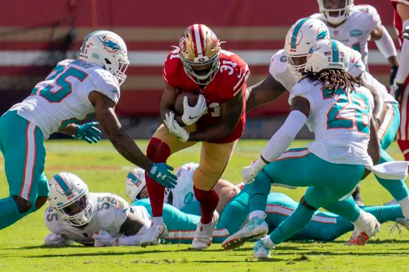 October 11, 2020; Santa Clara, California, USA; San Francisco 49ers running back Raheem Mostert (31) is tackled by Miami Dolphins cornerback Xavien Howard (25) and strong safety Bobby McCain (28) during the second quarter at Levi’s Stadium. Mandatory Credit: Kyle Terada-USA TODAY Sports/Reuters